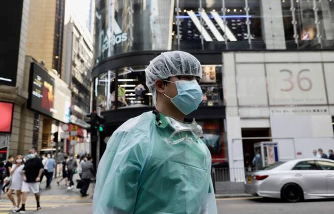 March 24, 2020, Hong Kong, CHINA: A man clad in bio-protective gear walk past financial centre in Central, Hong Kong.Mar-24,2020 Hong Kong.ZUMA Hong Kong CHINA - ZUMAl137 20200324_zap_l137_004 Copyright: xLiauxChung-renx