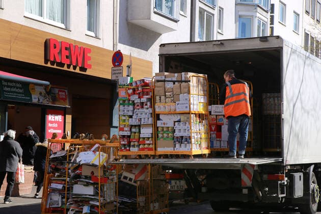 24 03 2020 Dortmund, NRW The corona crisis is worsening The federal and state governments are issuing comprehensive guidelines In all areas of life, Dortmunds citizens are also experiencing severe restrictions While customers stand in a queue in front of a REWE store until they are admitted, a driver delivers the coveted new goods in roll boxes