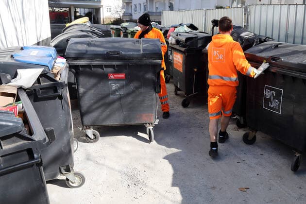 24 03 2020, Berlin, GER Employees of BSR push emptied residual waste bins back to
