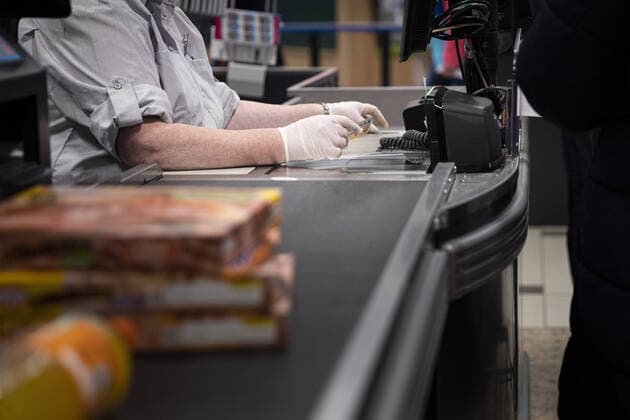 A cashier accepts money with gloves, taken in a supermarket in Goerlitz, 24 03 2020 Throughout Saxony, there are exit restrictions due to the spread of the corona virus Goerlitz Germany Copyright: xFlorianxGaertner photothek.netx