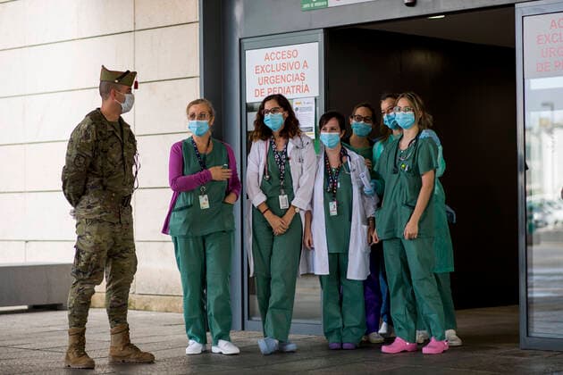 March 24, 2020, Granada, Spain: A member of La Legion of the Spanish army together with health staff at the emergency door, during the covid-19 pandemic..After 11 days of the state of emergency in Spain due to the coronavirus outbreak, there are more than 29,900 infected and 2,700 deaths. Granada Spain - ZUMAs197 20200324_zaa_s197_041 Copyright: xCarlosxGilx