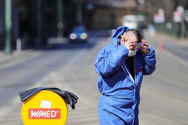 March 24, 2020, Cracow, Lesser Poland, Poland: Worker putting on his protective outfit as a preventive measure during the corona pandemic..Municipal cleaning services spray disinfectants in public places, including public transport stops as a preventive measure against the coronavirus pandemic. Cracow Poland - ZUMAs197 20200324_zaa_s197_065 Copyright: xFilipxRadwanskix