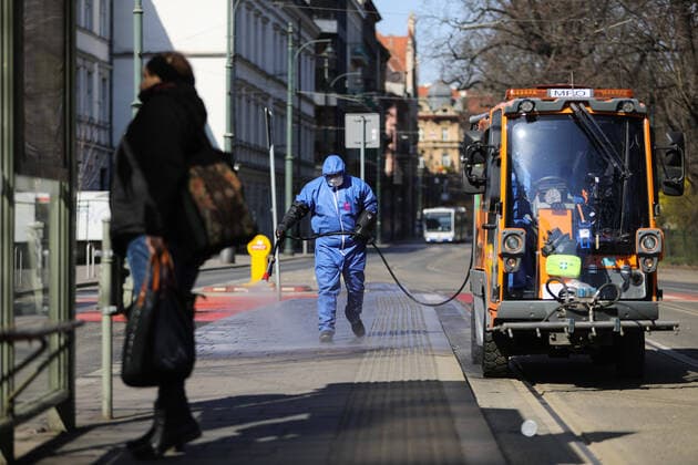 March 24, 2020, Cracow, Lesser Poland, Poland: Worker wearing a protective suit as a preventive measure while doing the disinfection during the corona pandemic..Municipal cleaning services spray disinfectants in public places, including public transport stops as a preventive measure against the coronavirus pandemic. Cracow Poland - ZUMAs197 20200324_zaa_s197_073 Copyright: xFilipxRadwanskix