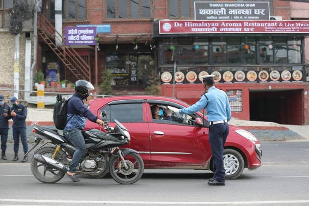 (200325) -- KATHMANDU, March 25, 2020 -- A policeman checks a vehicle on street in Kathmandu, Nepal, March 24, 2020. Nepal on Monday decided to enforce a national lockdown for a week effective from Tuesday to prevent the spread of COVID-19. ) NEPAL-KATHMANDU-COVID-19-LOCKDOWN TangxWei 