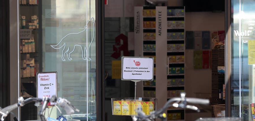 Entrance to a pharmacy, sign at the entrance Please enter individually, maximum 3 patients in the Wolfenbuettel pharmacy