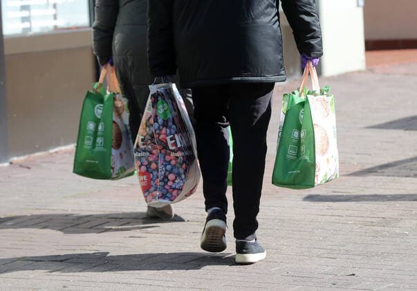 Mensdchen with shopping bags, purple protective gloves are worn Wolfenbuettel