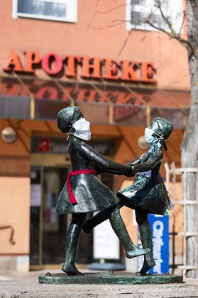Unknown persons have attached breathing masks to the statue of two dancing girls in the center of Jena The statue is standing in front of a pharmacy Photo from 24 3 2020