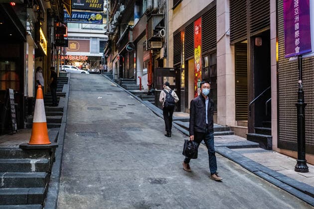 March 24, 2020, Hong Kong, China: A man walks through an empty street with a face mask as a preventive measure during the corona virus pandemic..As the coronavirus outbreak worsens, routine continues for businessmen and residents around the city, people wear face masks in fear of contracting the virus. Hong Kong China - ZUMAs197 20200324_zaa_s197_115 Copyright: xWilliexSiaux