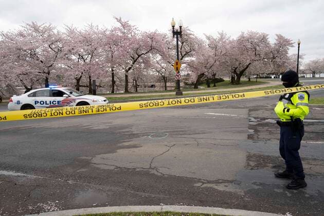 March 24, 2020, Washinton, District of Columbia, USA: A D.C. Metropolitan Police officer stands behind yellow tape to enforce road closures around the Tidal Basin cherry blossoms on Tuesday, March 24, 2020, in Washington, District of Columbia. Washinton USA - ZUMAg214 20200324_znp_g214_009 Copyright: xSaitxSerkanxGurbuzx