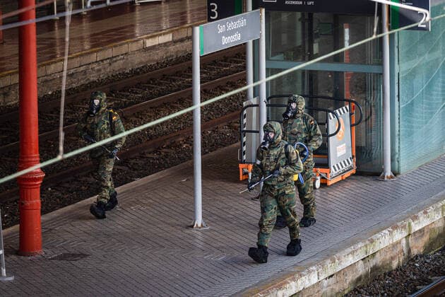 March 24, 2020, San Sebastian, Basque Country, Spain: Military personnel in protective suits pass by the sign at the Donostia - San Sebastian station, ready to begin disinfection work at the San Sebastian train station, to stop the expansion of Covid 19. ..A device made up of 62 soldiers from the Spanish Army disinfected the train station in San Sebastian, a city in the Basque Country, Spain, on Tuesday, as a preventive measure against the spread of the coronavirus COVID-19..during the corona virus pandemic..Soldiers doing disinfection work during the corona virus pandemic..62 soldiers from the Spanish Army disinfected the San Sebastian train station in the Basque County, as a preventive measure against the spread of the coronavirus San Sebastian Spain - ZUMAs197 20200324_zaa_s197_144 Copyright: xJavixJuliox