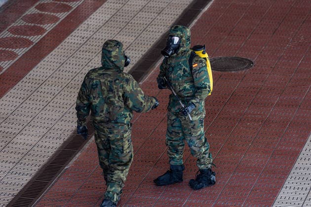 March 24, 2020, San Sebastian, Basque Country, Spain: Two Spanish army soldiers wearing protective masks talk to each other to carry out disinfection tasks at the San Sebastian train station, Spain..A device made up of 62 soldiers from the Spanish Army disinfected the train station in San Sebastian, a city in the Basque Country, Spain, on Tuesday, as a preventive measure against the spread of the coronavirus COVID-19..during the corona virus pandemic..Soldiers doing disinfection work during the corona virus pandemic..62 soldiers from the Spanish Army disinfected the San Sebastian train station in the Basque County, as a preventive measure against the spread of the coronavirus San Sebastian Spain - ZUMAs197 20200324_zaa_s197_155 Copyright: xJavixJuliox