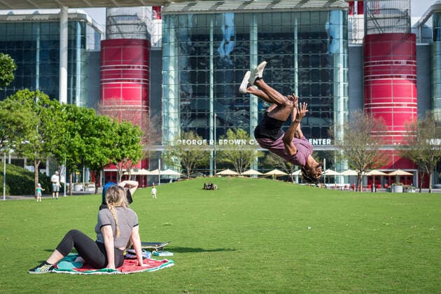 March 24, 2020, Houston, Texas, USA: ZACHERY PHILLIPS does a backflip at Discovery Green in downtown Houston, Tuesday, March 24, 2020. Zachery and his friends Alexis and Tessa, are enjoying the park. A Stay Home - Work Safe Order was issued Tuesday for Houston and Harris County residents to help fight the spread of COVID-19. The order will go into effect at 11:59 p.m. and will last until April 3. Houston USA - ZUMAp213 20200324_znp_p213_001 Copyright: xLynnxPenningtonx
