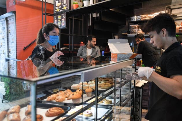 (200325) -- SANTIAGO, March 25, 2020 (Xinhua) -- A customer wearing mask orders at a cafe in Santiago, Chile, March 24, 2020. Chile had 922 confirmed cases of COVID-19 and two deaths, the Ministry of Health of Chile announced Tuesday. (Photo by Jorge Villegas Xinhua) CHILE-SANTIAGO-COVID-19 