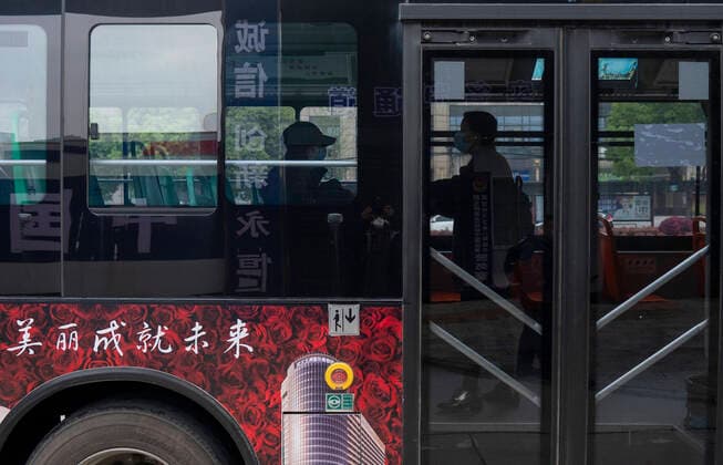 (200325) -- WUHAN, March 25, 2020 -- People take a bus in Wuhan, central China s Hubei Province, March 25, 2020. Wuhan, the once hardest-hit city in central China s Hubei Province during the COVID-19 outbreak, resumed a total of 117 bus routes starting Wednesday, around 30 percent of the city s total bus transport capacity, the municipal transport bureau said. According to a spokesperson of the bureau, passengers must wear masks, register with their names and scan a QR code, and take a temperature check before taking buses and subways. ) CHINA-HUBEI-WUHAN-COVID-19-BUS ROUTES-RESUMPTION (CN) CaixYang