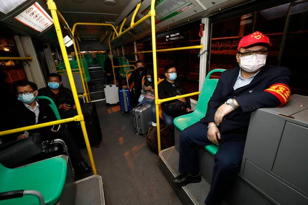 (200325) -- WUHAN, March 25, 2020 -- People take a bus in Wuhan, central China s Hubei Province, March 25, 2020. Wuhan, the once hardest-hit city in central China s Hubei Province during the COVID-19 outbreak, resumed a total of 117 bus routes starting Wednesday, around 30 percent of the city s total bus transport capacity, the municipal transport bureau said. According to a spokesperson of the bureau, passengers must wear masks, register with their names and scan a QR code, and take a temperature check before taking buses and subways. ) CHINA-HUBEI-WUHAN-COVID-19-BUS ROUTES-RESUMPTION (CN) ShenxBohan