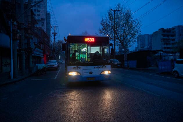 (200325) -- WUHAN, March 25, 2020 -- An early bus runs on a road in Wuhan, central China s Hubei Province, March 25, 2020. Wuhan, the once hardest-hit city in central China s Hubei Province during the COVID-19 outbreak, resumed a total of 117 bus routes starting Wednesday, around 30 percent of the city s total bus transport capacity, the municipal transport bureau said. According to a spokesperson of the bureau, passengers must wear masks, register with their names and scan a QR code, and take a temperature check before taking buses and subways. ) CHINA-HUBEI-WUHAN-COVID-19-BUS ROUTES-RESUMPTION (CN) CaixYang