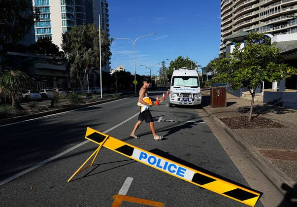 QLD BORDER CLOSURE, A beachgoer crosses the road where a checkpoint is to be set up on the Queensland NSW boarder in Coolangatta, Wednesday, March 25, 2020. The Queensland border will close at midnight on Wednesday as authorities try to stop the spread of COVID-19. ( NO ARCHIVING, EDITORIAL USE ONLY, NO USE IN BOOKS WITHOUT CONSENT BRISBANE QLD AUSTRALIA  Copyright: xDAVExHUNTx 20200325001459511247