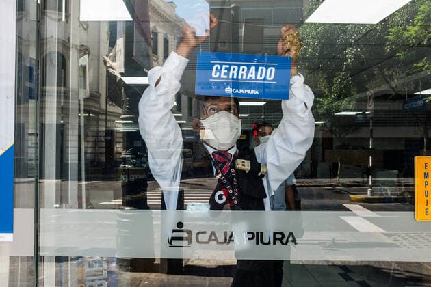 March 24, 2020, Lima, Peru: A security officer wearing a face mask as a precaution against the spread of Coronavirus places a closing sign at the bank..Due to the threat of the coronavirus pandemic, on March 15 President Vizcarra declared the national state of emergency and the suspension of the exercise of constitutional rights related to personal freedom and security, inviolability of the home and freedom of assembly and transit in the territory for 15 days. Currently, in Peru there are 416 registered cases and 7 deaths from Covid-19. Lima Peru - ZUMAs197 20200324_zaa_s197_220 Copyright: xSergixRugrandx