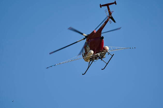 Spraying helicopter in action 25 03 2020, Rhineland-Palatinate, Kobern Gondorf A spraying helicopter flies over the vines near the Moselle town of Kobern Gondorf Mayen Koblenz district The vines are sprayed with fungicides from the air