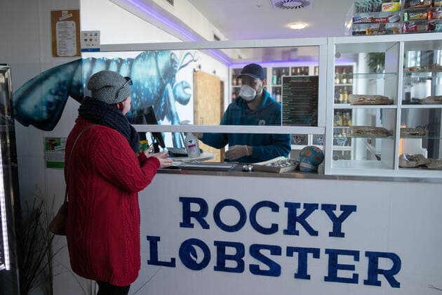 Hanover, Corona crisis, caterers fighting for survival, The catering service Rocky Lobster has opened a streetfood store in an old canteen, at the cash desk Lauritz Trabandt, with a breathing mask,