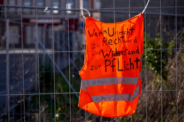 Warning vest 25 03 2020, Rheinland Pfalz, Koblenz Lützel On an orange warning vest attached to a site fence, it says If injustice becomes right, resistance becomes a duty feeAssange