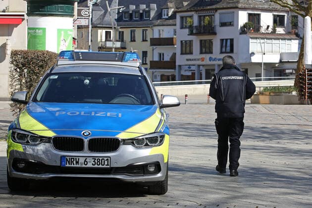 Coronavirus fear, effects because of the coronavirus Covid 19 , the city center of Siegen is almost empty at noon, police car in the city center, an employee of the public order office passes by city center on 25 03 2020 in Siegen Germany