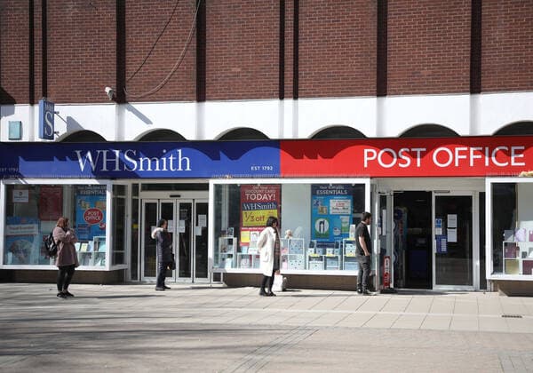 Day Two of Lockdown in Peterborough. People maintain personal distancing whilsts queueing outside the WH Smith Post Office in Peterborough. The country is on lockdown due to the COVID-19 Coronavirus pandemic. People are not allowed to leave home except for minimal food shopping, medical treatment, exercise - once a day, and essential work. COVID-19 Coronavirus lockdown, Peterborough, Cambridgeshire, UK, on March 25, 2020 