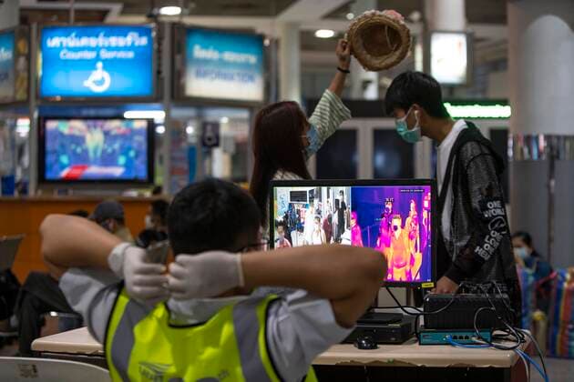 March 25, 2020, Bangkok, Bangkok, Thailand: Passengers walk past a thermal imaging camera put in place to detect possible symptoms of the Covid-19 virus at the entrance to Bangkok s Mochit Bus Terminal. Prime Minister Prayut Chan-O-Cha declared that starting at midnight March 26, 2020 Thailand would institute the most comprehensive lockdown procedures so far to combat the spread of Covid-19. For the third day in a row crowds of passengers gathered at Bangkok s Mochit Bus Terminal to leave the city, many making the decision to leave the Thai capital due to the mass closure of businesses causing financial burden on the city s economically insecure workforce. Bangkok Thailand - ZUMAt128 20200325_zap_t128_007 Copyright: xAdryelxTalamantesx