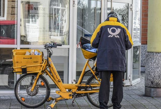 A postman at work in an otherwise almost deserted city Public life is largely shut down, shops and stores closed, mail, garbage collection and other system-relevant occupational groups are still on the move in Freiburg Photo Winfried Rothermel