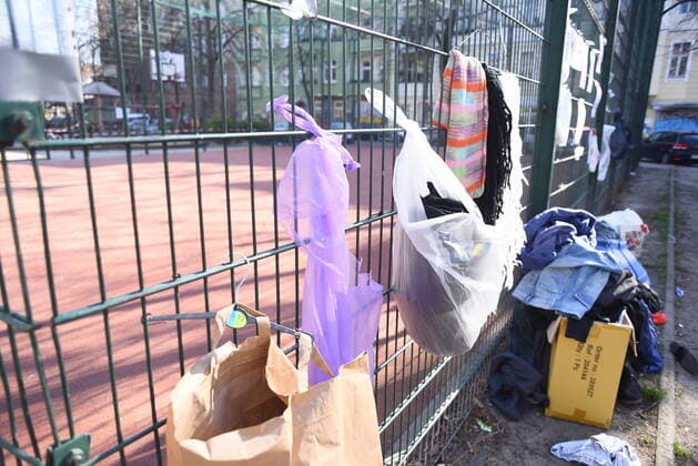 Some of the donation bags for homeless people hanging on this fence at Reuterplatz in Neukölln have already been emptied