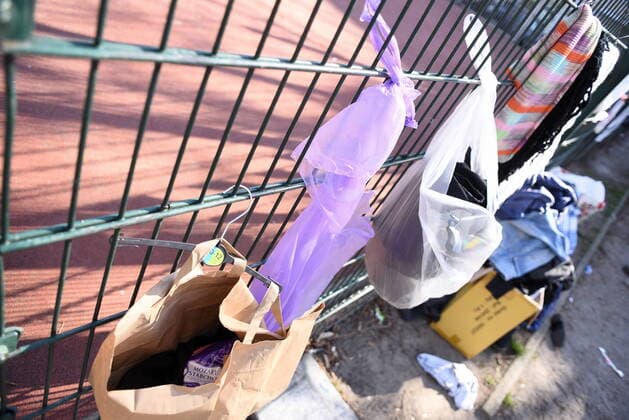Some of the donation bags for homeless people hanging on this fence at Reuterplatz in Neukölln have already been emptied