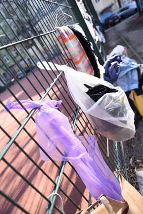 Some of the donation bags for homeless people hanging on this fence at Reuterplatz in Neukölln have already been emptied