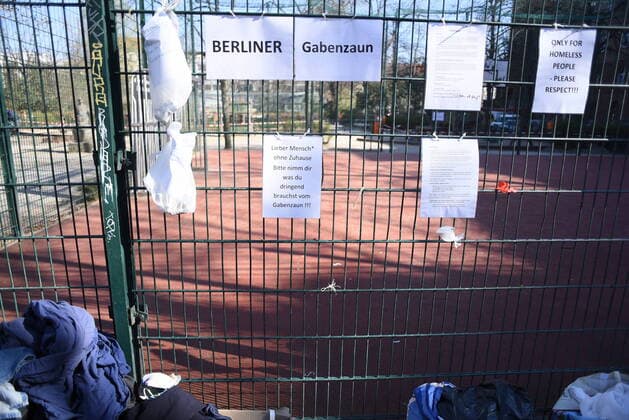 Some of the donation bags for homeless people hanging on this fence at Reuterplatz in Neukölln have already been emptied