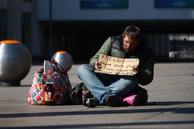 A homeless person begs in front of the exit of the subway in an empty Alexanderplatz in Berlin on 25 March 2020 In order to slow down the spread of the coronavirus COVID 19, the federal and state governments decided to impose further restrictions After museums, theatres, sports events etc. have been banned,