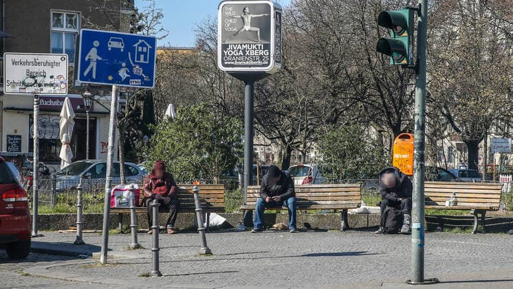 Coronavirus in Berlin Berlin, 25 03 2020, Kreuzberg Three homeless people sit on park benches at a distance on a square in Kreuzberg During the coronavirus crisis, homeless people have to fight as risk groups with massive restrictions on their basic care and medical assistance Berlin Berlin Germany Kreuzberg