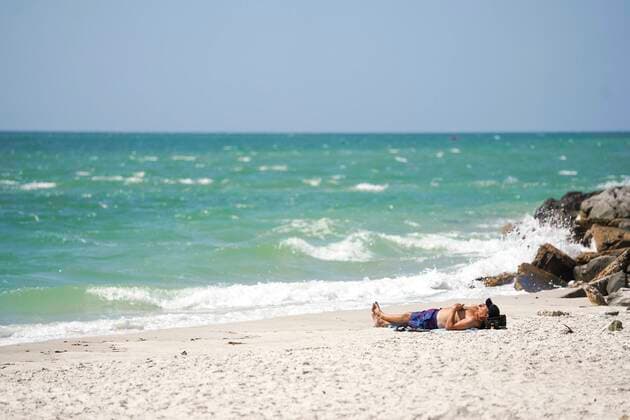 March 25, 2020, Madeira Beach, Florida, USA: A man sunbathes on a small beach at John s Pass on Wednesday, March 25, 2020 in Madeira Beach. Madeira Beach USA - ZUMAs70_ 20200325_zan_s70_093 Copyright: xMarthaxAsencioxRhinex