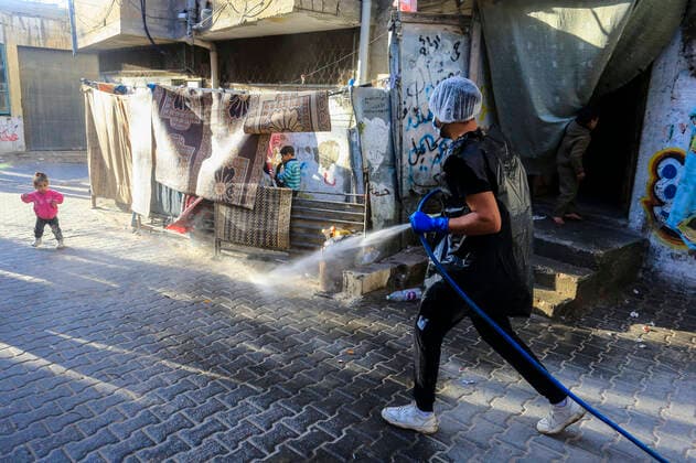 March 25, 2020, Gaza City, The Gaza Strip, Palestine: A Palestinian sprays disinfectant as a precaution against the spread of the Covid-19 coronavirus, in the streets of the Jabalia refugee camp, northern Gaza Strip, 25 March 2020. The Palestinian Ministry of Health in Gaza had confirmed on 22 March 2020 that there were two cases of novel coronavirus Covid-19 in the Gaza Strip. Gaza City Palestine - ZUMAq100 20200325_zaa_q100_052 Copyright: xMahmoudxIssax