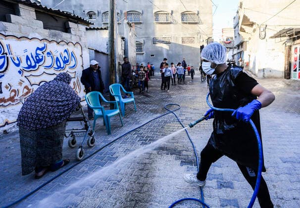 March 25, 2020, Gaza City, The Gaza Strip, Palestine: A Palestinian sprays disinfectant as a precaution against the spread of the Covid-19 coronavirus, in the streets of the Jabalia refugee camp, northern Gaza Strip, 25 March 2020. The Palestinian Ministry of Health in Gaza had confirmed on 22 March 2020 that there were two cases of novel coronavirus Covid-19 in the Gaza Strip. Gaza City Palestine - ZUMAq100 20200325_zaa_q100_064 Copyright: xMahmoudxIssax