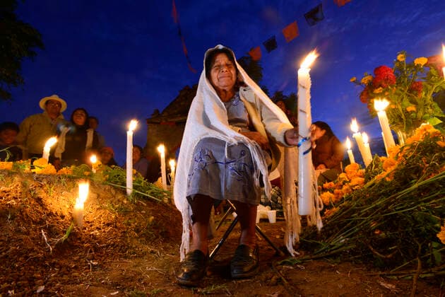 IMAGO Cultures of the world, Zapotec Kultur in Mexiko Zapotec woman holding candle among graves adorned with marigolds, Atzompa, Oaxaca, Mexico, North America Copyright: RaulxTouzon 1318-158