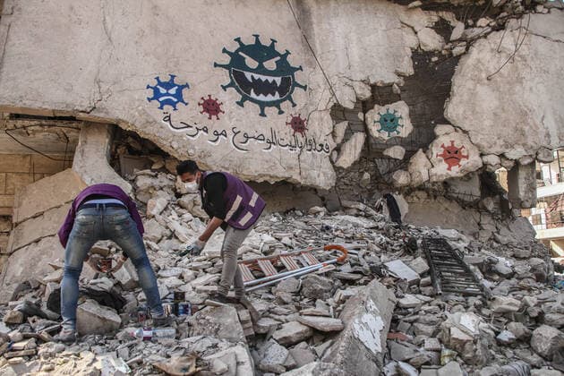 March 26, 2020: The photos show volunteers from Violet NGO drawing a painting on one of the walls destroyed by the bombing in the middle of Idlib governorate in northern Syria. The painting aims to educate people about the danger of the Corona virus and the importance of their stay in homes during this period while the virus ends - ZUMAa323 20200326_zip_a323_011 Copyright: xMoawiaxAtrashx