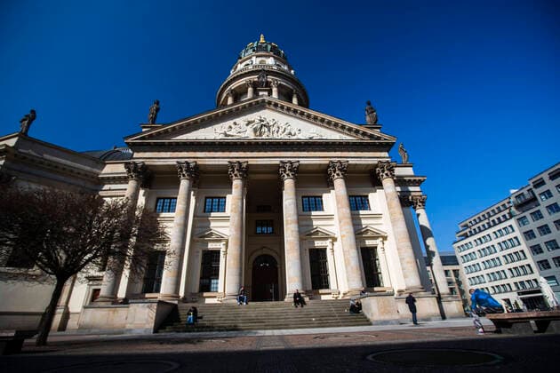A few people are enjoying the sun at the Gendarmenmarkt in Berlin on 26 March 2020 To slow down the spread of the coronavirus SARS CoV 2, the federal and state governments decided to impose further restr