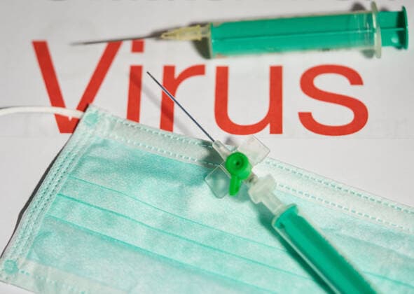 Covid-19 symbol in Marktoberdorf, Germany, March 26, 2020. Injection needle for vaccination and a mouth protection, due to the Corona virus disease (COVID-19) . on March 26, 2020 in Marktoberdorf, Germany