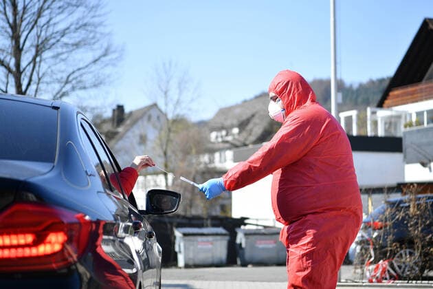 (200326) -- LENNESTADT (GERMANY), March 26, 2020 (Xinhua) -- A healthcare worker takes a sample from a driver to test for possible COVID-19 infection at a drive-through test station in Lennestadt, Germany, on March 26, 2020. Confirmed cases of COVID-19 in Germany increased by 4,954 within one day to 36,508, the Robert Koch Institute (RKI) announced on Thursday. The number of deaths from COVID-19 increased from 149 to 198, according to RKI, the federal government agency and research institute responsible for disease control and prevention. (Photo by Ulrich Hufnagel Xinhua) GERMANY-LENNESTADT-COVID-19-DRIVE-THROUGH TEST