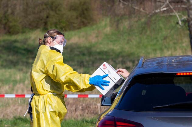 (200326) -- ISERLOHN (GERMANY), March 26, 2020 (Xinhua) -- A healthcare worker takes a sample from a driver to test for possible COVID-19 infection at a drive-through test station in Iserlohn, Germany, on March 26, 2020. Confirmed cases of COVID-19 in Germany increased by 4,954 within one day to 36,508, the Robert Koch Institute (RKI) announced on Thursday. The number of deaths from COVID-19 increased from 149 to 198, according to RKI, the federal government agency and research institute responsible for disease control and prevention. (Photo by Joachim Bywaletz Xinhua) GERMANY-ISERLOHN-COVID-19-DRIVE-THROUGH TEST