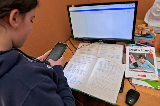 26 02 2020, Children and Family, Modelreleased Schoolchild Viola from Bavaria is teaching from home because of the Corona Pandemic At her desk and computer she learns new material every day via e-mail and a special school app TEAMS Here she scans her exercise book on her smartphone and sends it via app to the teacher 26 02 2020, Children and Family, homeschooling 26 02 2020, Children and Family, homeschoolin