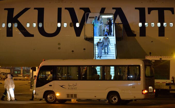 (200326) -- FARWANIYA GOVERNORATE (KUWAIT), March 26, 2020 (Xinhua) -- Kuwaiti citizens evacuated from abroad disembark from a plane at Kuwait International Airport in Farwaniya Governorate, Kuwait, on March 26, 2020. Kuwait reported 13 new COVID-19 cases over the past 24 hours, bringing the total number of confirmed cases in the country to 208, the Health Ministry announced Thursday. (Photo by Asad Xinhua) KUWAIT-FARWANIYA GOVERNORATE-COVID-19-MEASURES 
