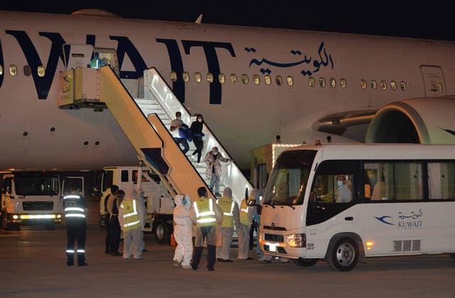 (200326) -- FARWANIYA GOVERNORATE (KUWAIT), March 26, 2020 (Xinhua) -- Kuwaiti citizens evacuated from abroad disembark from a plane at Kuwait International Airport in Farwaniya Governorate, Kuwait, on March 26, 2020. Kuwait reported 13 new COVID-19 cases over the past 24 hours, bringing the total number of confirmed cases in the country to 208, the Health Ministry announced Thursday. (Photo by Asad Xinhua) KUWAIT-FARWANIYA GOVERNORATE-COVID-19-MEASURES 