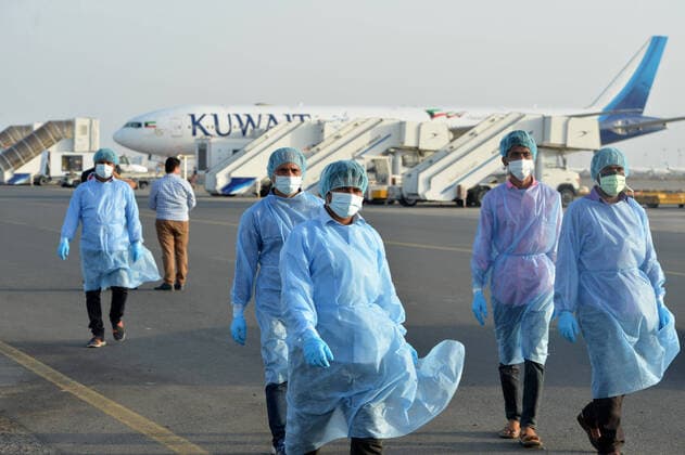 (200326) -- FARWANIYA GOVERNORATE (KUWAIT), March 26, 2020 (Xinhua) -- Medical workers walk to a temporary health check center at Kuwait International Airport in Farwaniya Governorate, Kuwait, on March 26, 2020. Kuwait reported 13 new COVID-19 cases over the past 24 hours, bringing the total number of confirmed cases in the country to 208, the Health Ministry announced Thursday. (Photo by Asad Xinhua) KUWAIT-FARWANIYA GOVERNORATE-COVID-19-MEASURES 