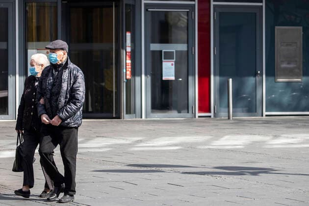 27 03 2020, DU Duisburg , Corona paralyzes Duisburg city center , People wearing mouthguards , Homeless people in groups , Police checks an elderly couple Senior citizens wearing mouthguards in the city center