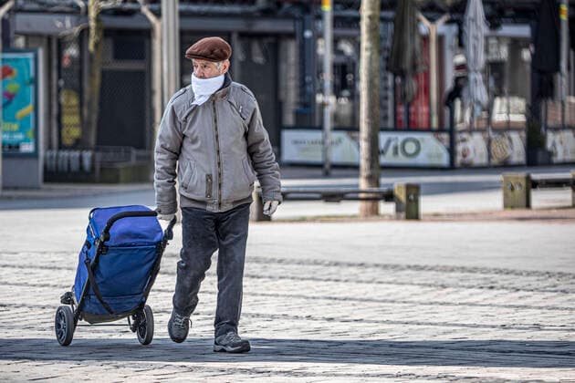 27 03 2020, DU Duisburg , Corona paralyzes Duisburg city center , People with mouthguards on the way , Homeless people in groups on the way , Police checks an elderly man with mouthguards in the city center on the way